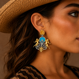 Close-up of a model wearing sterling silver Baroque cherub drop earrings with turquoise stone