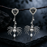 Sterling silver gothic spider drop earrings with black onyx lotus stud, hanging from a branch