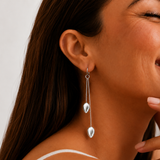 Close-up of a model wearing sterling silver twin chain drop earrings with teardrop silver beads